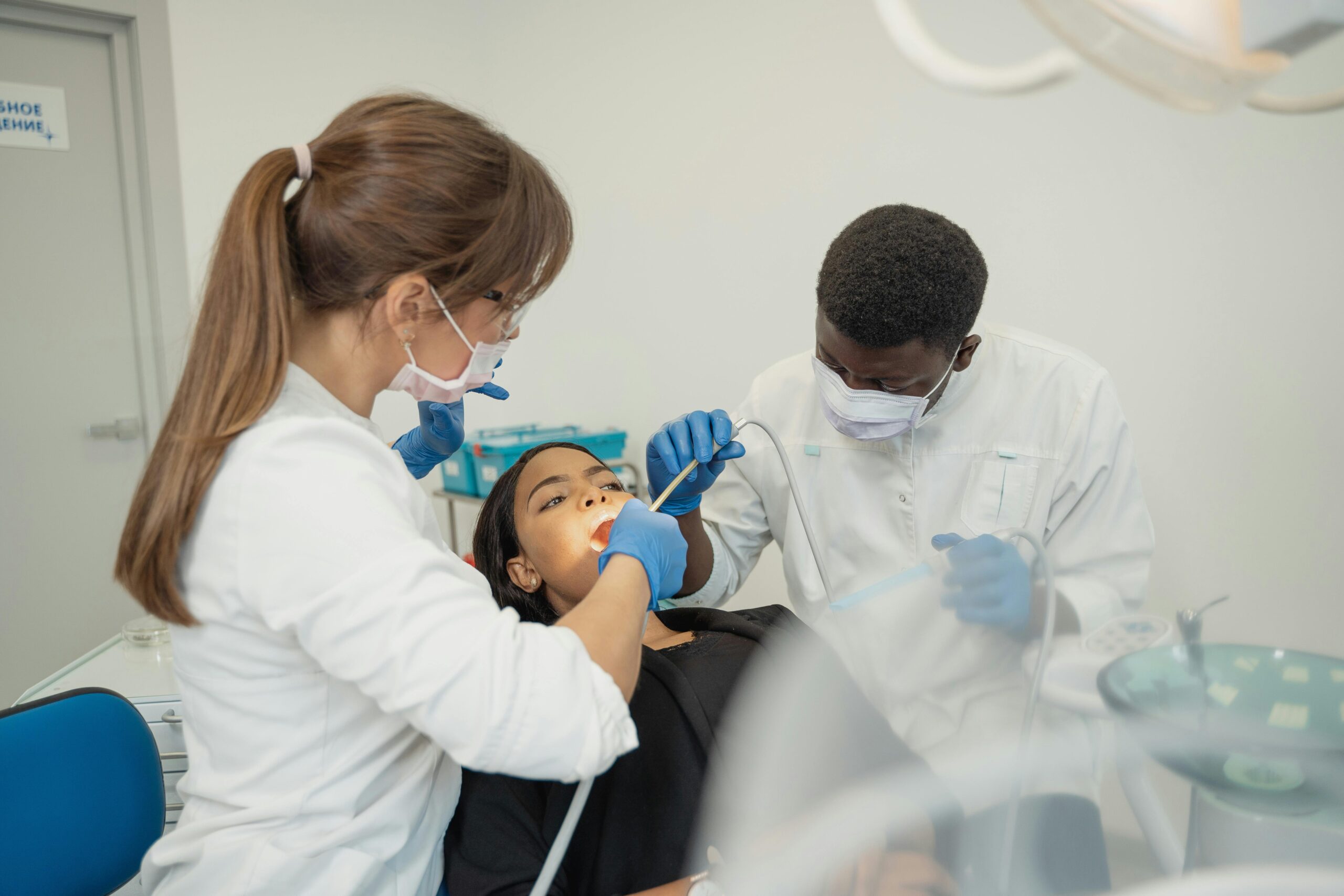 Dentist and her assistant operating on a patient