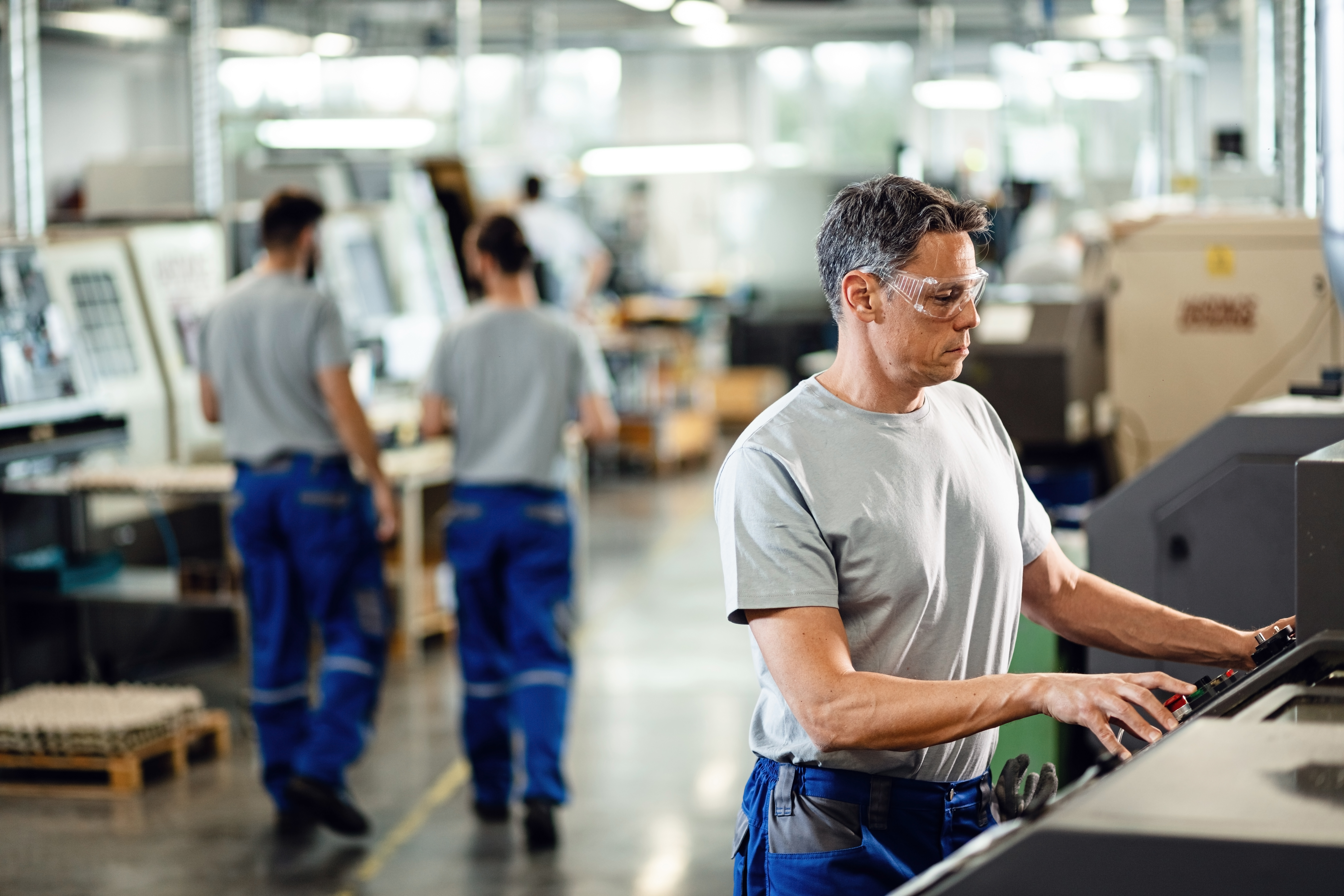 A worker operating machinery in a manufacturing facility. A worker operating machinery in a manufacturing facility.